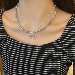 Doellagige Halskette mit schickem Schleifenanhänger und Metallperlen für einen eleganten Look