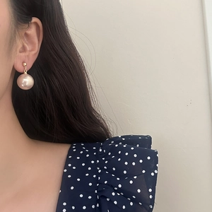 French vintage champagne pearl stud earrings with gold finish on elegant female model