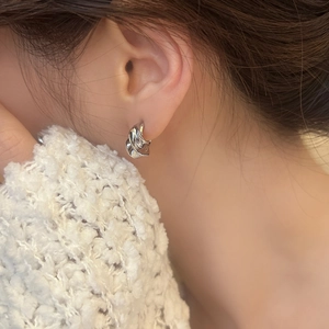 French retro style silver irregular spiral hoop earrings shown on a female model