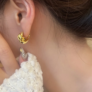 French vintage style irregular gold metal spiral earrings on female model