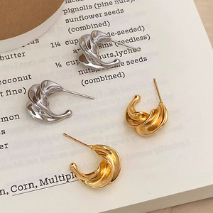 Irregular spiral hoop earrings in gold and silver finish with minimalist twisted design