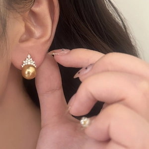 Elegant gold crown pearl earrings with marquise cubic zirconia on a female model