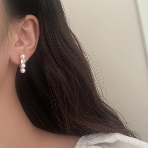 Detail of French style pearl and zircon earrings worn by a model in close-up shot