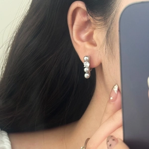 Close-up of elegant silver pearl zircon earrings worn by a model in a lifestyle setting