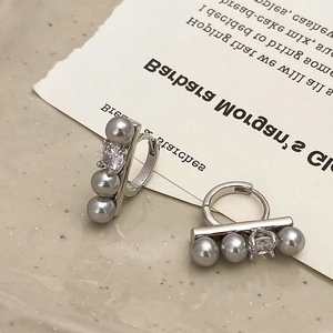 Detailed close-up of French style earrings with gray pearls and sparkling zircons