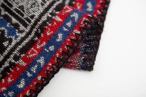 Macro view of ethnic geometric jacquard fabric with black blanket stitch edge detail