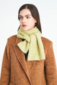 Detail of light green wool knit scarf showing soft mohair texture on a brown coat