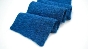 Close-up of deep blue knitted wool scarf showing thick, fluffy mohair texture and warmth