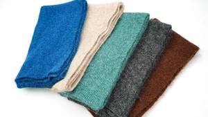 Detail view of colorful knit wool scarves in royal blue, beige, grey, and brown tones