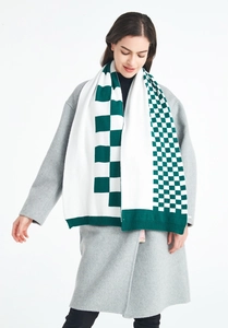 Detail of dark green and white plaid knitted scarf on a grey coat with thick wool texture