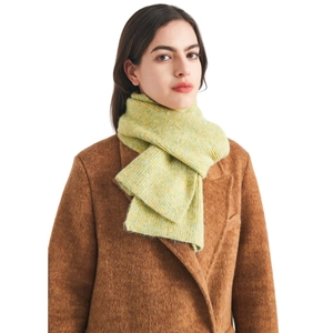 Knitted wool scarf in yellow-green heathered yarn paired with a dark brown wool coat