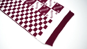 Close-up of jacquard knit scarf with red and white checkerboard geometric patterns