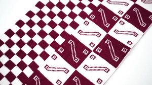 Detailed close-up of burgundy and beige jacquard knit scarf with checkerboard patterns