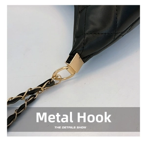 Detailed macro view of the golden hardware hook and leather-threaded chain on a black bag