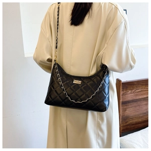 Quilted diamond chain bag on model in beige trench coat, back view detail showing the texture