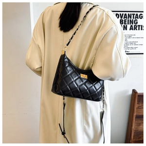 Quilted diamond chain bag worn with a beige coat, highlighting the elegant drape and size