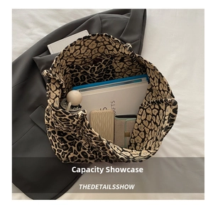 Interior detail of leopard print tote bag showing storage capacity for books and umbrella