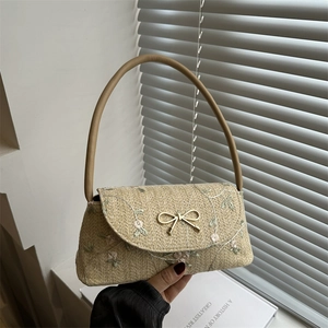 Beige straw woven shoulder bag featuring pink floral embroidery and a bow detail