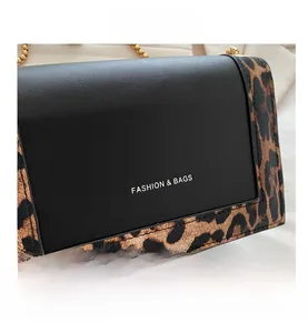 Detail of leopard print stitching and golden chain strap on a stylish crossbody bag