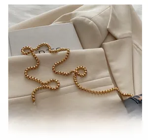 Detailed close-up of golden box-chain strap on a chic leopard print crossbody bag