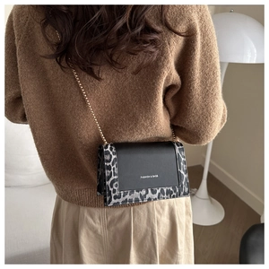 Detail of square leopard print crossbody bag with gold chain strap on a model
