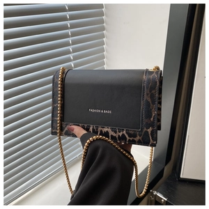 Detail view of leopard print crossbody bag with gold chain strap and fashion logo