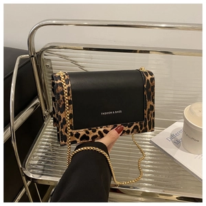 Detail view of fashion square handbag featuring leopard print panels and golden chain strap