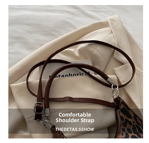 Détail de la boucle en métal réglable et de la bandoulière en cuir du sac léopard
