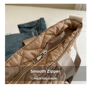 Nahaufnahme vom glatten Metallreißverschluss und Steppstoff dieser khakifarbener Tasche