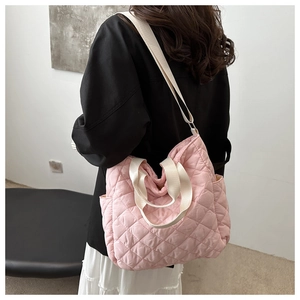Detail der rosa gesteppten Einkaufstasche mit weißem Gurtbandgriff und Schultergurt am Model