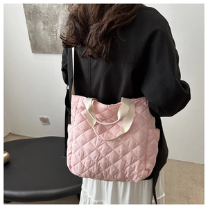 Rückansicht eines Models mit rosa gesteppter Nylon-Einkaufstasche und elfenbeinbeigen Riemen