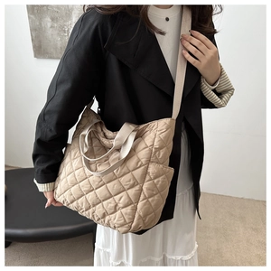 Détail d'un sac à bandoulière matelassé beige avec losanges et large sangle croisée