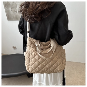 Détail d'un sac cabas matelassé beige avec poches latérales et bandoulière rembourrée