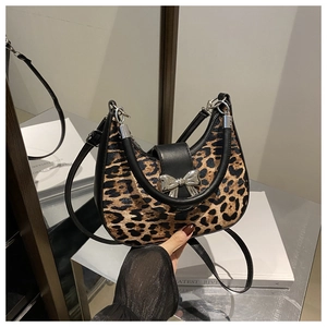 Détail du sac léopard avec boucle en nœud argenté et fine bandoulière en cuir noir