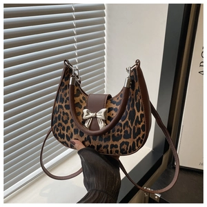 Détail du sac croissant à imprimé léopard avec boucle nœud argenté et bandoulière cuir