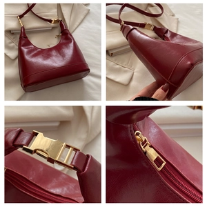 Detail view of burgundy hobo bag with glossy finish and gold metal hardware accents
