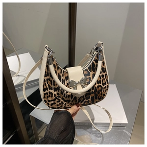 Détail du sac croissant imprimé léopard avec bordure en cuir crème et nœud argenté