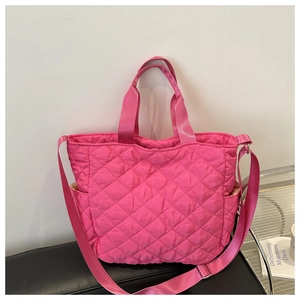 Détail du cabas matelassé en nylon fuchsia avec poche latérale et bandoulière réglable