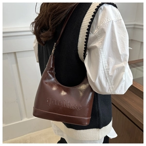 Close-up of dark brown hobo bag with embossed lettering on high-quality matte leather