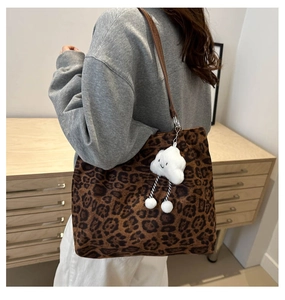 Leopard print tote bag detail with brown leather strap and plush cloud charm decor