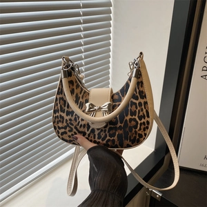 Sac croissant léopard avec bordure en cuir crème et boucle en forme de nœud doré