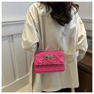 Detail of hot pink crossbody bag with silver butterfly clasp and fashion embossed text