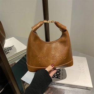 Brown vintage crescent-shaped handbag with twisted handle and gold metallic buckle