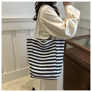 Detail of the navy striped canvas tote bag showing the thick rope handle and textured fabric