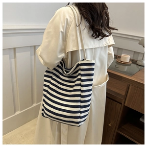 Détail du sac cabas en toile à rayures bleues et blanches avec bandoulière en corde