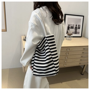 Lifestyle view of black and white striped canvas tote bag with thick rope shoulder straps