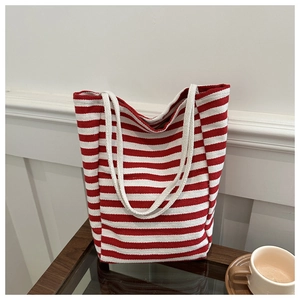 Vue détaillée d'un sac cabas en toile à rayures rouges et blanches sur une table