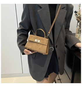 Brown frosted velvet mini Kelly bag shown styled with a grey blazer for a modern look