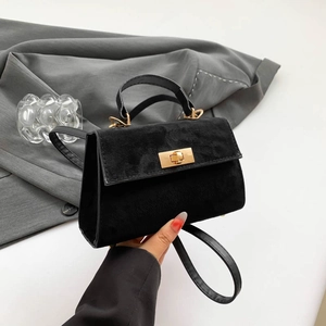 Minimalist black matte crossbody bag with gold hardware and trapezoid structure