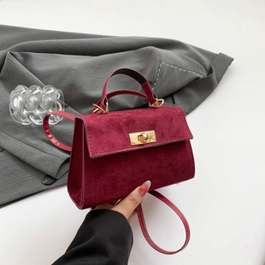 Minimalist burgundy suede crossbody bag with gold turn-lock and adjustable strap